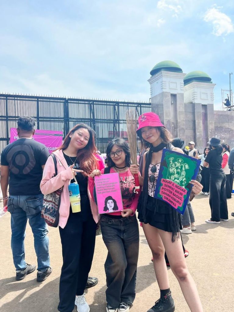 Massa aksi Aliansi Perempuan Indonesia mengangkat sapu di depan gedung DPR